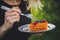 Woman eating a chocolate covered blueberry and raspberry pice of cake