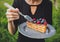 Woman eating a chocolate covered blueberry and raspberry pice of cake