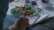 Woman eating detail on dish.Four caucasian friends people mediterranean italian salad,meat steak and bread lunch or