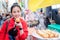 Woman eating Egg bread with almond, peanut and sunflower seed at Myeong-dong street food, Seoul, South Korea