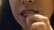 Woman eating french fries, unhealthy eating, risk of gastritis, close-up of face