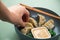 Woman eating fried Dim Sum Gyoza dumplings with Wakame seaweed salad and sesame sauce in bowl with finger