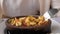 Woman is eating frying hot shrimps with vegetables served in clay bowl, closeup dish.