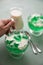 Woman eating green woodruff jelly and vanilla custard with spoon