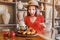 Woman eating grilled tabaka chickens with tkemali sauce in a traditional Georgian rustic restaurant