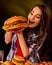 Woman eating hamburger. Girl bite of very big burger