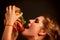 Woman eating hamburger. Student consume fast food.