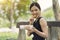 Woman eating healthy peanut butter sandwich cracker sitting at park, appetizer lunch box