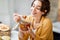 Woman eating honey at home