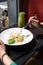 Woman eating italian pasta sitting at the cafe counter looking to the window, having lunch