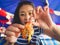 Woman eating local grilled seafood of Thailand beach.