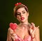 Woman eating lollipops. Girl in pin-up style hold striped candy.