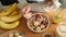 Woman eating oatmeal porridge with fruits and nuts for breakfast