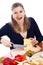 Woman eating olives and cutting emmenthal cheese