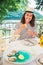 Woman eating oysters in outdoors restaurant at sunny summer weather