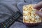 Woman eating popcorns with remote control and warm blanket