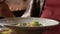 Woman eating salad in an outdoor cafe, close up on a plate