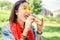 Woman eating sandwich and having lunch break outdoors in park