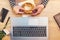 Woman eating sesame bagel for breakfast in office, top view