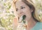 Woman eating spring flowers at garden.