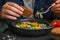 Woman eating tasty Shakshuka at table, closeup