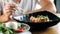 Woman eating traditional asian soba stir-fry noodles with shrimp