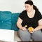 Woman eating unhealthy food watching series online