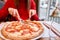 Woman eats with knife and fork a pizza capricciosa. Pizza with mozzarella tomatoes, Artichoke, black olives and basil