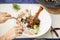 Woman eats lamb shank at dinner table