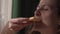 A woman eats pizza. Caucasian woman holding a slice of pizza. Appetizing.