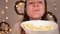 Woman eats popcorn, Christmas lights on a blury background A woman with a huge popcorn-full mouth chews and smiles. funny