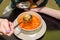 Woman eats red vegetable soup in restaurant