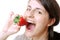 Woman eats a strawberry