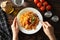 Woman eats tasty pasta Composition with pasta on wooden background