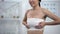 Woman in elasto-fit breast compression touching wrap, feeling pain after surgery