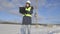 Woman electrical engineer writing and using binoculars near high voltage line