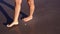 Woman elegant bare feet walk along beach wet sand closeup