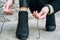 Woman in elegant clothes tying shoelaces on shoes close up