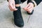 Woman in elegant clothes tying shoelaces on shoes close up