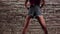 Woman elegant in the crop top and denim shorts dance twerk against a brick wall. Slow motion. Close up