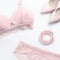 Woman elegant pink lace bra and panties, jewelry. Stylish lingerie flat lay. Underwear fashion concept