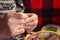 A woman embroiders with a cross. Wrinkled hands close up