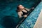 Woman emerging from swimming underwater at the pool.