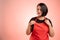 Woman employed at supermarket with red apron and black t-shirt arrange her apron