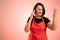 Woman employed at supermarket with red apron and black t-shirt displeased face and gestures and talking on cellphone