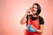 Woman employed at supermarket with red apron and black t-shirt happy talking on an old phone