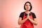 Woman employed at supermarket with red apron and black t-shirt praying