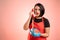 Woman employed at supermarket with red apron and black t-shirt scared talking on an old phone