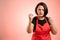 Woman employed at supermarket with red apron and black t-shirt showing fists