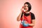 Woman employed at supermarket with red apron and black t-shirt talking on an old phone